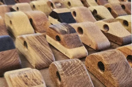 Rows of unfinished wooden toy cars waiting to be sanded.